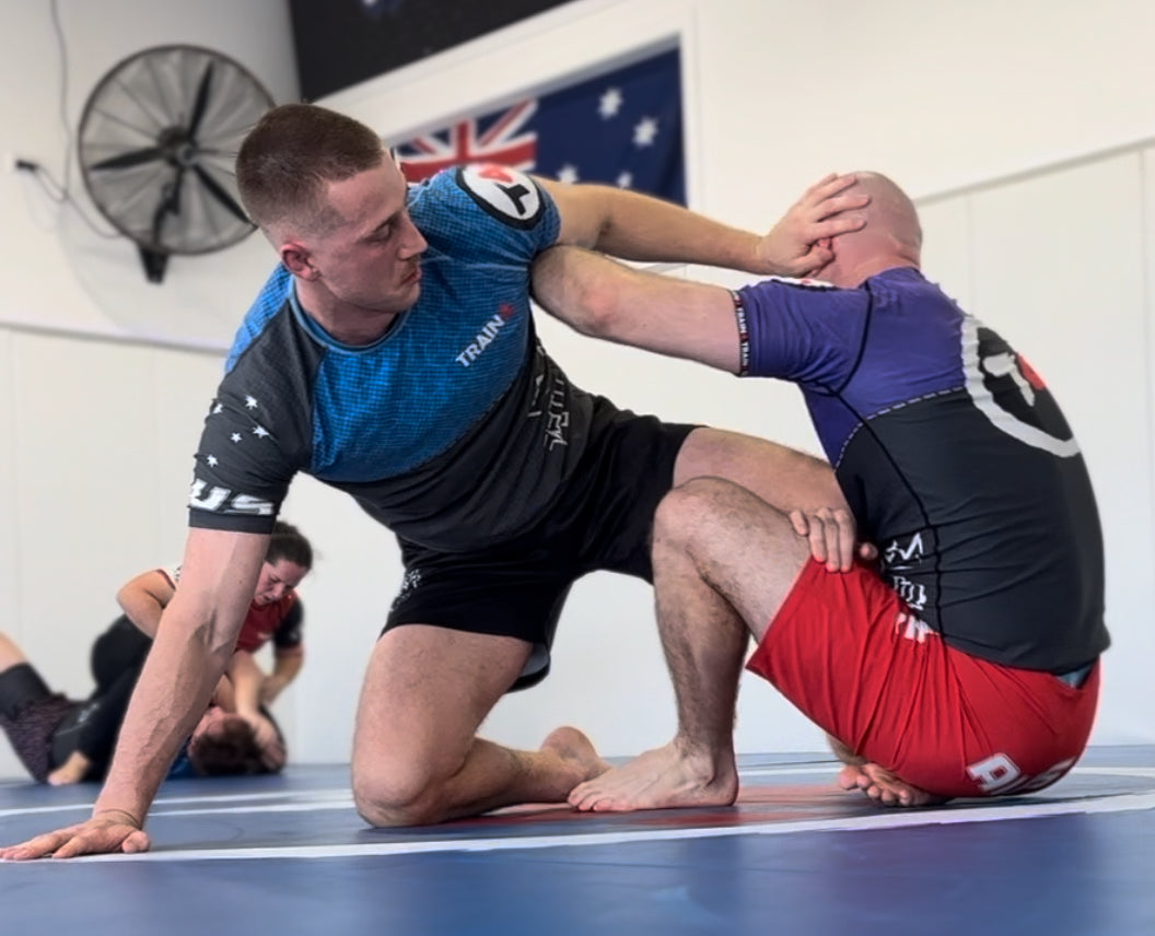 Two training partners practising NoGi technique on the Train4 mats