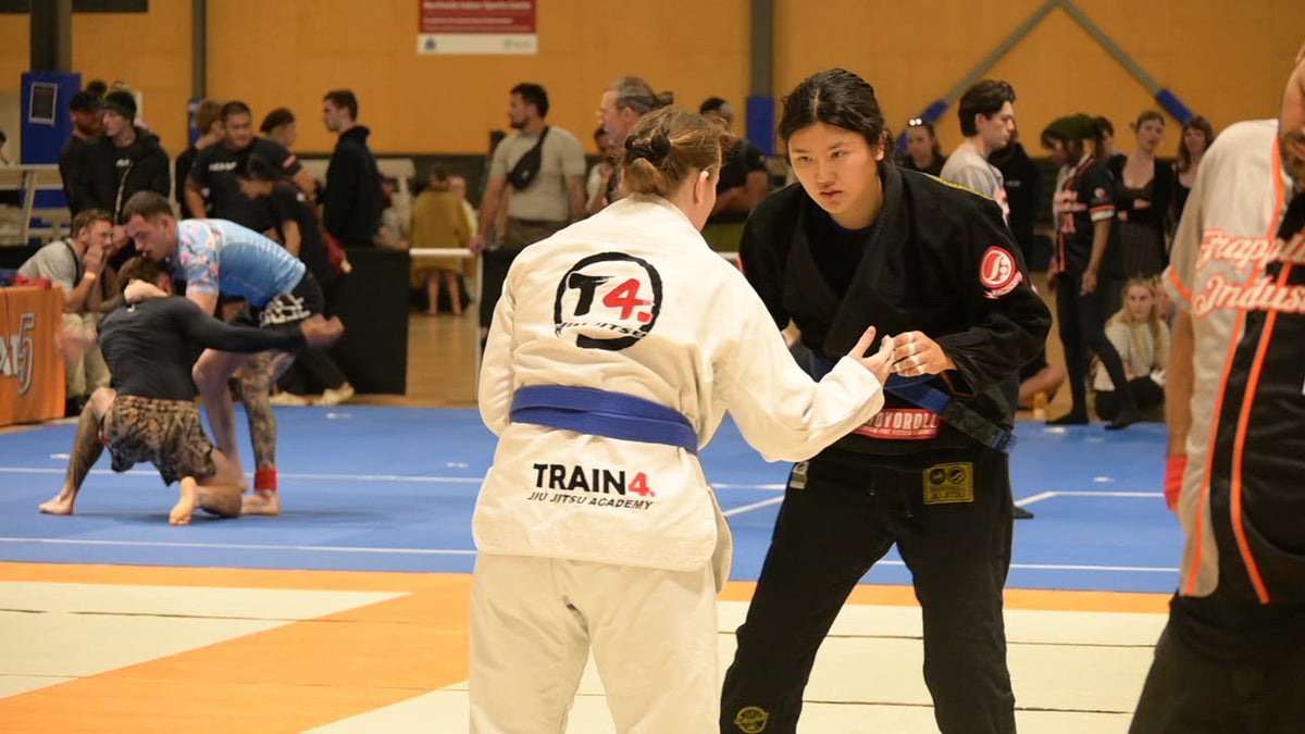 Two women practising standing grips in a Jiu-Jitsu competition